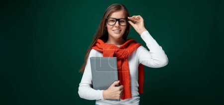 Photo for Smart young woman with brown hair holds a tablet in her hand. - Royalty Free Image
