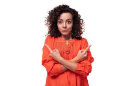 Téléchargez les photos : Jeune femme d'affaires caucasienne réussie avec coiffure bouclée vêtue d'une chemise orange. - en image libre de droit