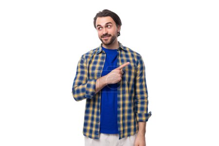 Téléchargez les photos : Jeune homme brutal caucasien avec visage non rasé habillé en chemise à carreaux bleu isolé sur fond blanc avec espace de copie. - en image libre de droit