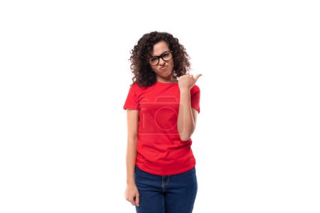 Téléchargez les photos : Portrait de mince jeune jolie femme brune bouclée portant un t-shirt rouge basique décontracté avec maquette. - en image libre de droit