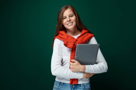 Photo for European young woman in a white turtleneck and red sweater holding a tablet. - Royalty Free Image