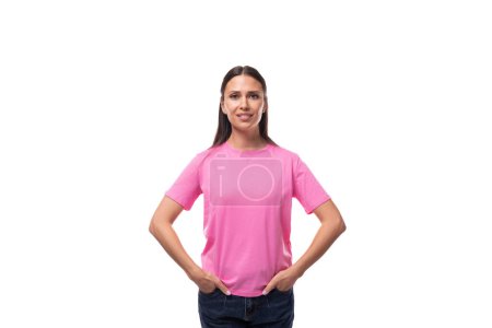 Téléchargez les photos : Jeune femme brune caucasienne mince dans un t-shirt rose sur un fond blanc avec espace de copie. - en image libre de droit