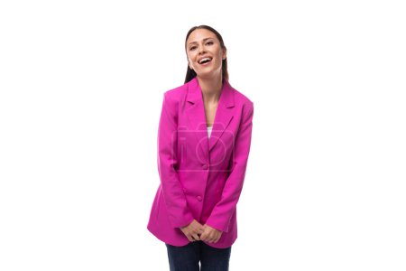 junge Büroangestellte Frau mit schwarzen Haaren in rosa Jacke sieht glücklich aus.