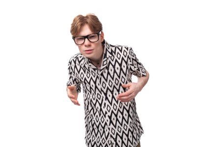 Foto de Primer plano de un joven pelirrojo en gafas con un tatuaje en el brazo tratando de ver los detalles en la distancia. - Imagen libre de derechos