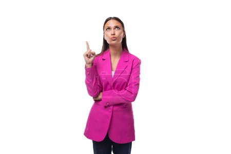 young smart office worker woman with black hair dressed in a pink jacket stands thoughtfully.