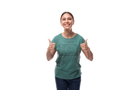 Foto de Joven mujer delgada y confiada vestida con una camiseta básica verde con maqueta de impresión. concepto de ropa corporativa. - Imagen libre de derechos