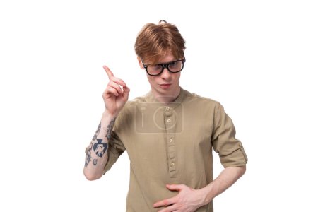 Foto de Joven hombre atento con el pelo corto rojo en gafas sobre un fondo blanco con espacio de copia. - Imagen libre de derechos