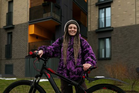 Lifestyle-Konzept. Junge Frau läuft mit Fahrrad im städtischen Umfeld.