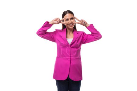 young office worker woman with black hair dressed in a pink jacket looks happy.