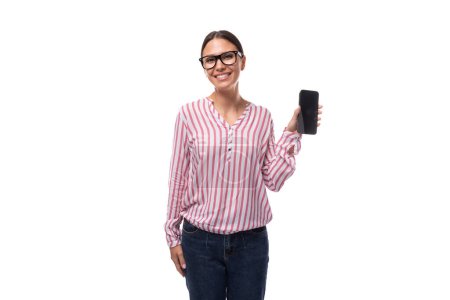 young lady office employee dressed in pink white blouse and jeans shows smartphone screen with mockup.