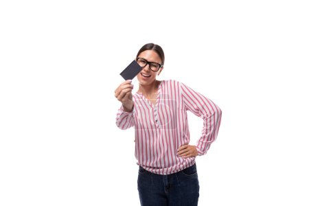 joven empleada de oficina vestida con una blusa blanca rosa y vaqueros con una tarjeta de crédito con una maqueta.