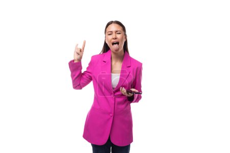 junge schlanke Büroangestellte mit schwarzen Haaren in fliederfarbener Jacke kommuniziert mit einem Smartphone.