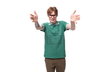 ein junger stylischer Mann mit roten Haaren im grünen T-Shirt will interessante Neuigkeiten erzählen und gestikuliert aktiv.