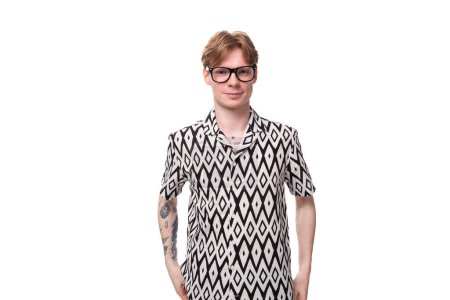 joven delgado guapo caucásico chico con pelo rojo en gafas y una camisa de verano sobre un fondo blanco con espacio de copia.