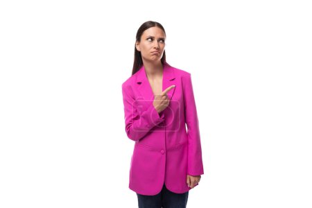 jeune femme de bureau intelligente avec les cheveux noirs habillés dans une veste rose se tient soigneusement.