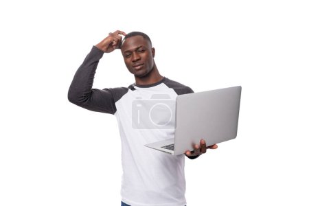 young successful student african guy with short haircut uses laptop for school.
