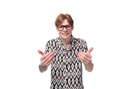 young indignant caucasian guy with red hair in glasses and a summer shirt on a white background with copy space.