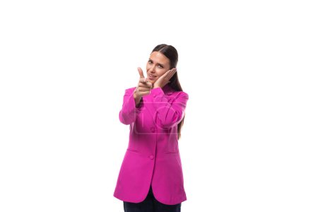 jeune patron femme vêtue d'une veste rose se tient pensivement sur un fond blanc.