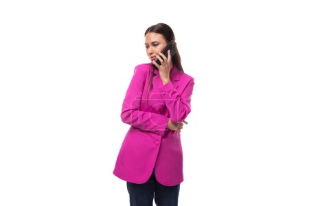 junge schlanke Büroangestellte mit schwarzen Haaren in fliederfarbener Jacke kommuniziert mit einem Smartphone.