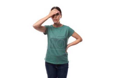 junge schlanke Europäerin mit Pferdeschwanzfrisur trägt ein grünes T-Shirt.