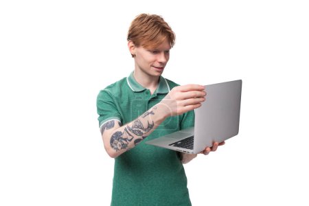 Téléchargez les photos : Jeune étudiant européen intelligent avec succès aux cheveux roux tenant un ordinateur portable. - en image libre de droit