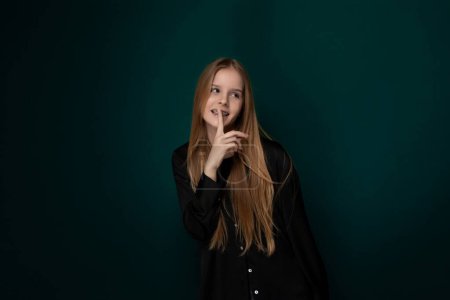 Eine junge Frau mit langen Haaren posiert vor der Kamera und präsentiert ihren einzigartigen Stil und ihr Selbstbewusstsein. Ihre ausdrucksstarke Gestik und elegante Haltung schaffen eine optisch ansprechende Komposition