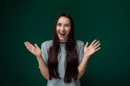 Photo for A woman with long hair is smiling and extending her hands outwards in a welcoming gesture. She appears happy and approachable, exuding warmth and openness in her body language. - Royalty Free Image