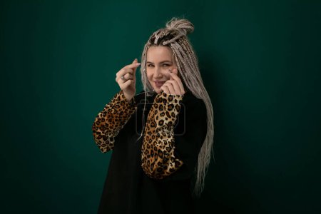 A mature woman with grey hair is seen wearing a stylish leopard print shirt. She exudes confidence and fashion-forwardness in her choice of clothing, showcasing a bold and trendy look.