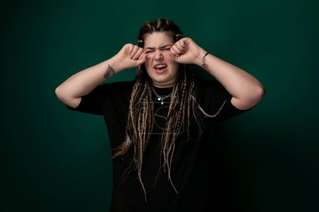 A woman with dreadlocks draped over her face, obscuring her eyes from view. The image captures her unique hairstyle and creates a sense of mystery and anonymity.