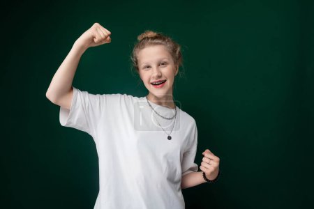 Photo for A woman is standing confidently, with her arm raised in a fist gesture. She exudes strength and determination as she poses for the camera. - Royalty Free Image