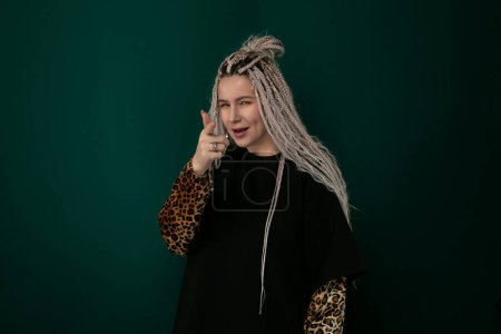 A woman with grey hair adorned in a stylish leopard print sleeve poses for a photograph. The contrast between her hair and the sleeve creates a bold and fashionable look.