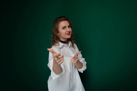 Photo for A woman wearing a white shirt is standing and making a gesture with her hands. She appears focused and engaged in her action, which is being captured in the moment. - Royalty Free Image