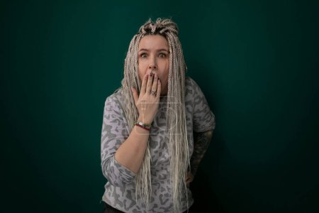 A woman with long hair covering her mouth with her hand, creating a sense of secrecy or hesitation. Her eyes are focused, hinting at inner turmoil or deep contemplation.