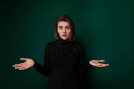 Photo for A woman wearing a black shirt is extending both of her hands outwards. She appears to be standing in a neutral position, with her hands slightly cupped. Her facial expression is neutral. - Royalty Free Image