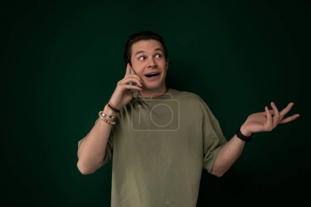 Photo for A man is animatedly talking on a cell phone, his expression contorted in a humorous or exaggerated manner. He gestures with his hands while speaking into the phone. - Royalty Free Image