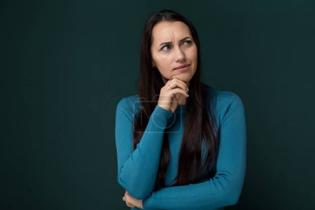 Eine Frau im blauen Hemd posiert für ein Foto. Sie steht selbstbewusst, mit einem Lächeln im Gesicht, während die Kamera sie im Moment einfängt.