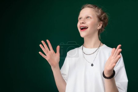 Photo for A Caucasian woman wearing a white shirt is standing with her arms extended outwards in a gesture of openness or surrender. - Royalty Free Image