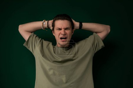 A stressed man is pictured standing with his hands resting on his head, indicating feelings of overwhelm, worry, or distress.