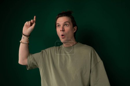 Ein Mann verdreht spielerisch seinen Gesichtsausdruck, indem er sich den Finger in den Mund steckt und eine humorvolle und dumme Geste macht.