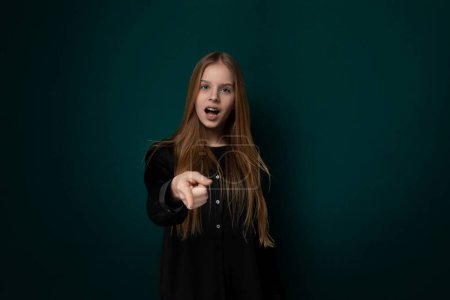 Photo for A woman standing and pointing directly at the camera with her finger, expressing a gesture of highlighting or emphasizing something. She appears confident and assertive in her action. - Royalty Free Image