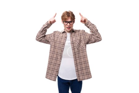 junger fröhlicher rothaariger Mann mit Brille im karierten Hemd auf weißem Hintergrund.