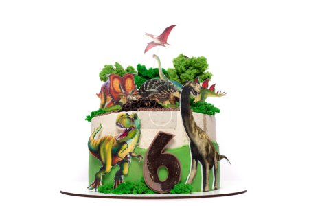 A birthday cake is adorned with colorful dinosaurs and a large number six made of icing. The cake is set against a festive backdrop, ready for celebration.