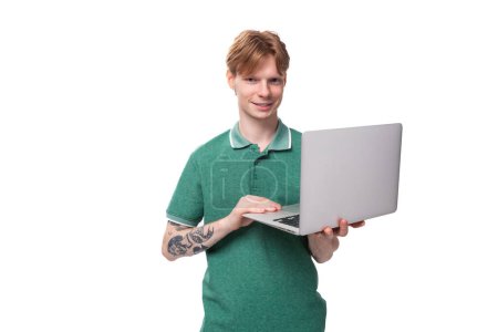 Foto de Joven inteligente exitoso estudiante europeo hombre con el pelo rojo sosteniendo un ordenador portátil. - Imagen libre de derechos