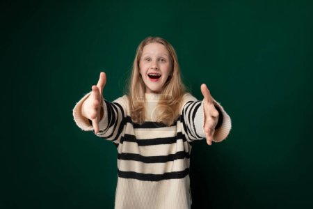 Una niña que lleva un suéter a rayas se muestra haciendo un gesto de la mano, su expresión facial insinuando determinación. Su mano se levanta con los dedos posicionados de una manera específica.