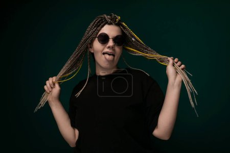 Eine Frau mit Dreadlocks hält ihre Haare hoch und demonstriert die Länge und Beschaffenheit ihrer Frisur. Ihre Hände sind sichtbar und zeigen die Dicke und das Volumen ihrer Dreadlocks.