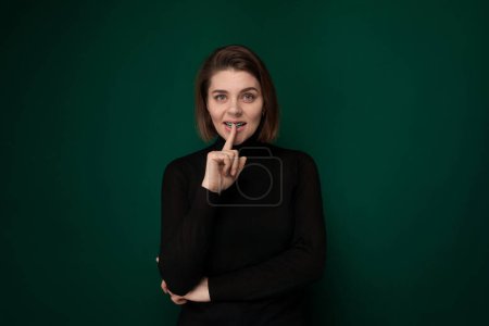 A woman poses for a picture with her finger in her mouth, expressing a playful or flirtatious gesture. Her gaze is directed towards the camera, engaging the viewer with her expression.