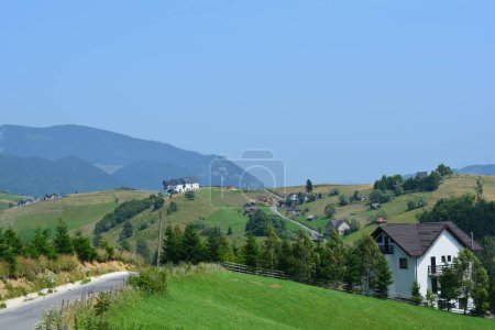 Casas de campo, caminos, colinas y cielos azules