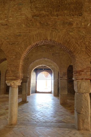 Photo for Almonaster la Real, Huelva, Spain, June 21, 2023: Vertical view. Interior arches of the haram or prayer room and side door of the 10th century mosque of Almonaster la Real. Huelva, Spain - Royalty Free Image
