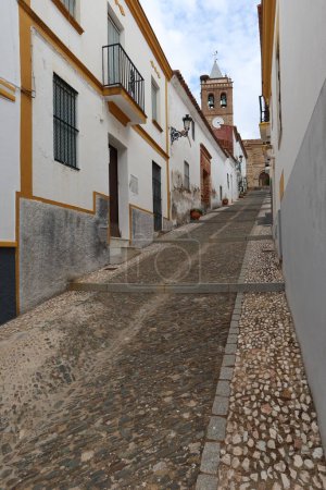 Photo for Almonaster la Real, Huelva, Spain, June 21, 2023: Cobbled street with the church on top in Almonaster la Real, Sierra de Aracena, Huelva, Spain - Royalty Free Image