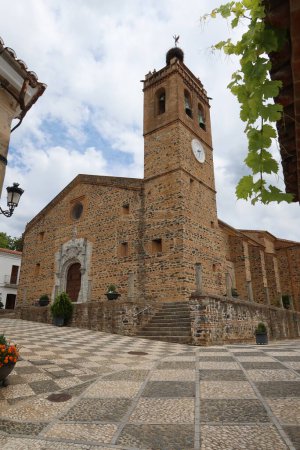 Photo for Almonaster la Real, Huelva, Spain, June 21, 2023: Vertical view of the Puerta del perdon and bell tower of the church of San Martin in Almonaster la Real, Sierra de Aracena, Huelva, Spain - Royalty Free Image